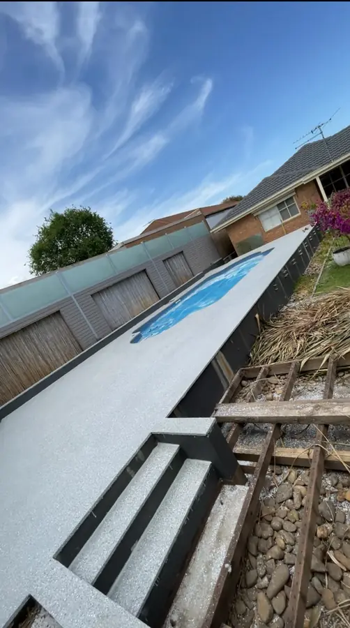 Light hybrid stone epoxy finish around an outdoor pool